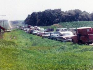 #259=Cars along road on day of farm sale; July 27, 1967